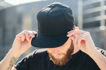 Hipster handsome male model with beard  wearing black blank  baseball cap  with space for your logo
