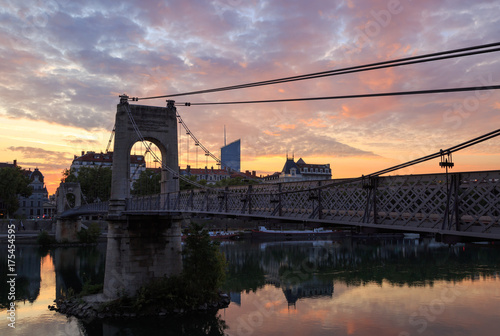 Footbridge Passerelle du College, over the Rhone river in Lyon, during a colorful sunrise.
