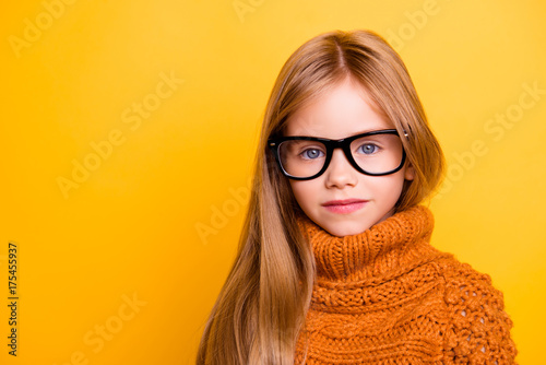 Health care, eyeball check, clear vision, youngsters concept. Close up portrait of charming blonde schoolgirl in fashionable black specs, knitted handmade warm outfit, intelligent and concentrated photo