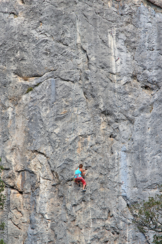 a brave climbing girl climbs a high rock