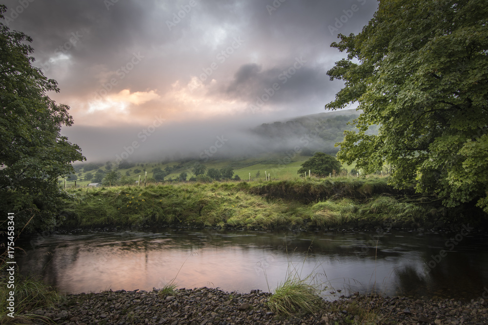 Fototapeta premium Early morning sunrise in the mist with river foreground England