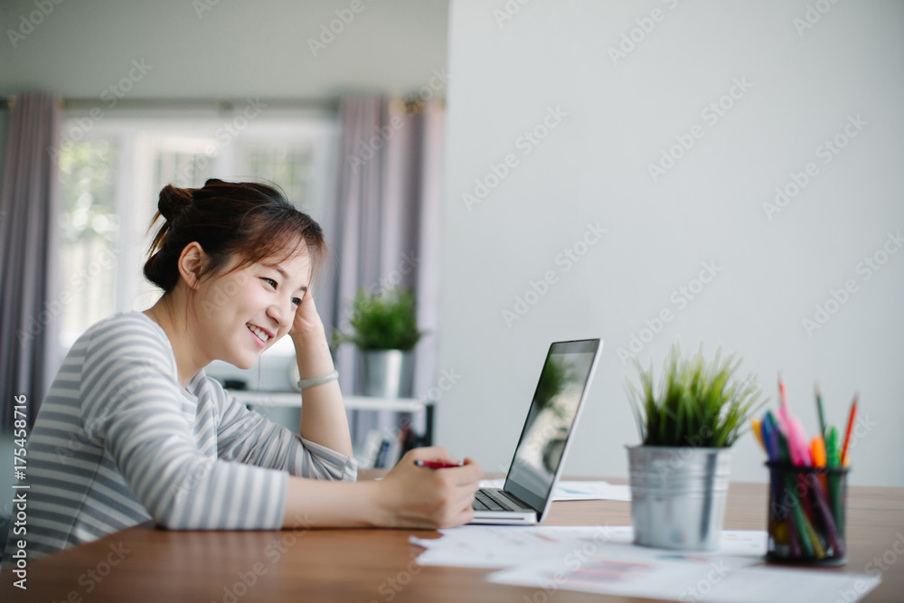 Beautiful young Asia woman working with laptop at home office Beautiful young Asia woman working with laptop at home office