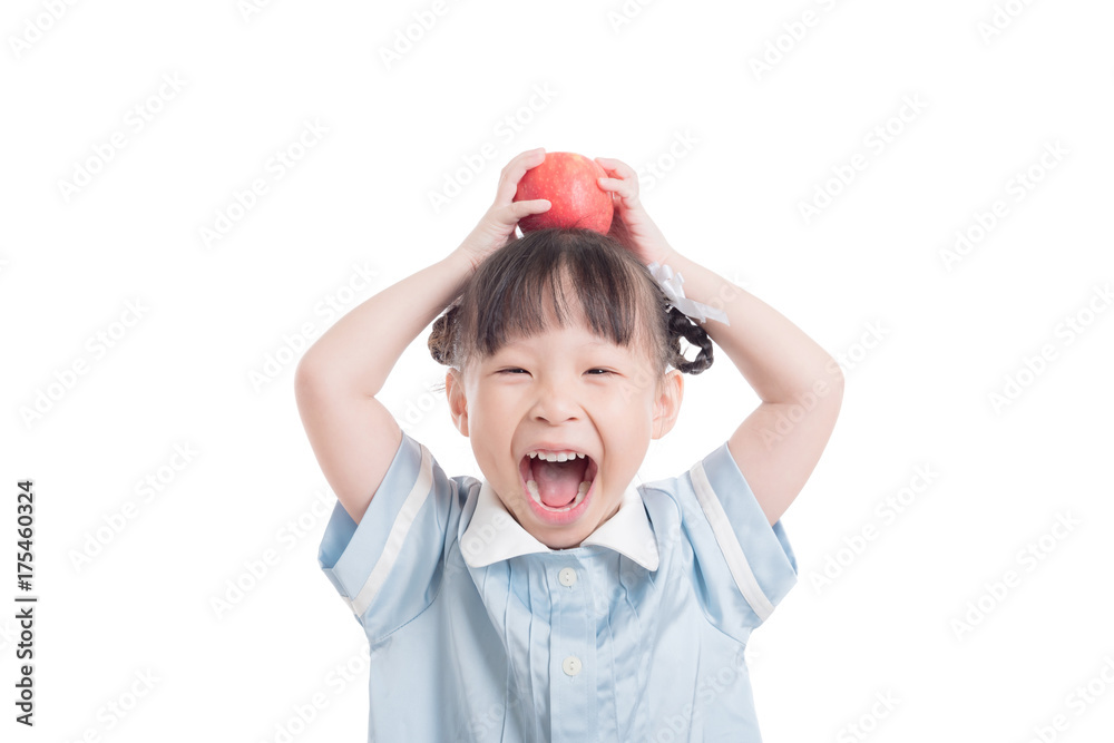 Little asian preschool girl put an apple on head and laughing over white background Little asian preschool girl put an apple on head and laughing over white background
