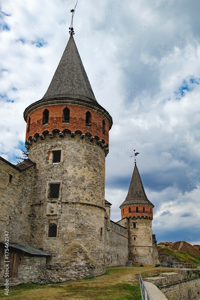 Tower of the old Kamianets-Podilskyi Castle under the cloudy blue sky. The fortress located among the picturesque nature in the historic city of Kamianets-Podilskyi, Ukraine.