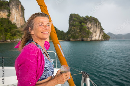 Woman sailing on yacht looking away smiling, Koh Hong, Thailand, Asia photo