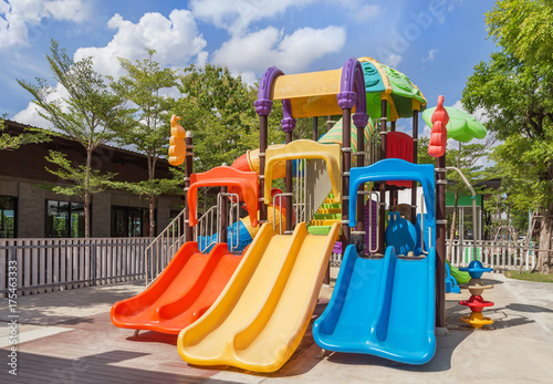 Colorful modern children playground in the park with blue sky background © Soonthorn