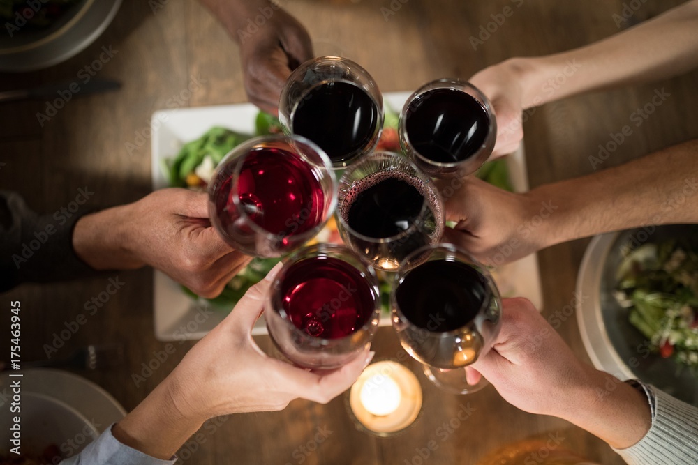 Friends toasting red wine in restaurant