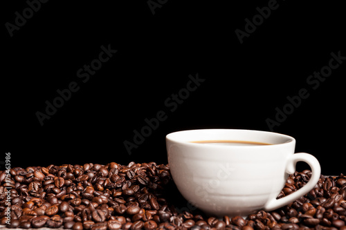 Coffee cup on coffee beans in close up photo. Refreshing beverage in the morning