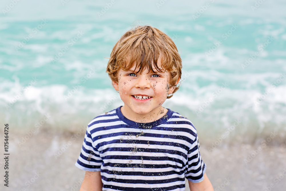 little kid boy running on the beach of ocean little kid boy running on the beach of ocean