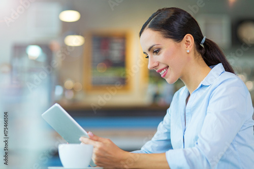 Woman using digital tablet in cafe 