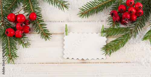 Christmas fir tree and blank paper on white wooden background