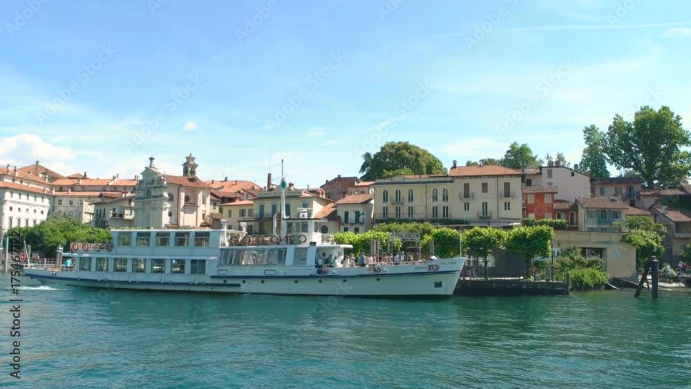 People on boat Isola Bella. Water, buildings and sky. People on boat Isola Bella. Water, buildings and sky.