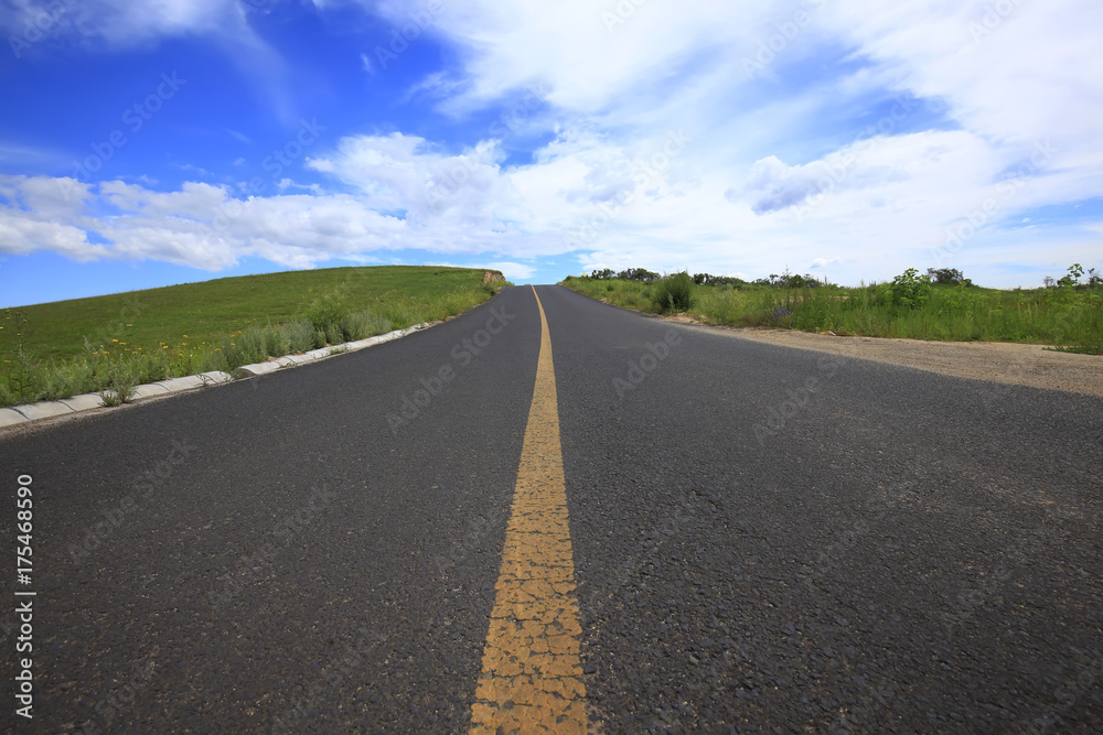 asphalt road on grassland