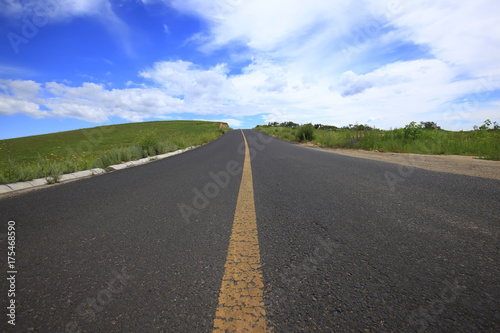 asphalt road on grassland