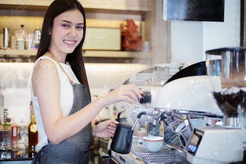 Asian women Barista smiling and using coffee machine in coffee shop counter - Working woman small business owner food and drink cafe concept