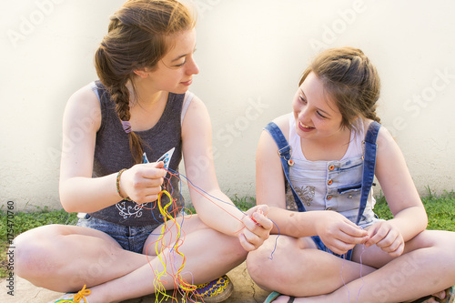 Two young people making bracelets.