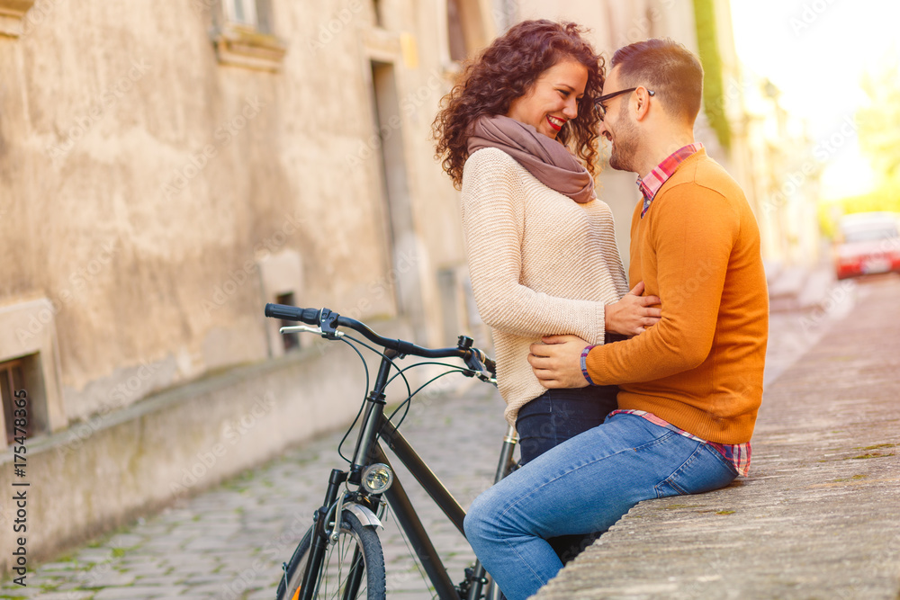 Happy young couple with a bicycle on sunny autumn day in the city. Happy young couple with a bicycle on sunny autumn day in the city.