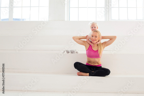 attractive fitness woman mother and baby gymnastics yoga exercises trained female body lifestyle white background