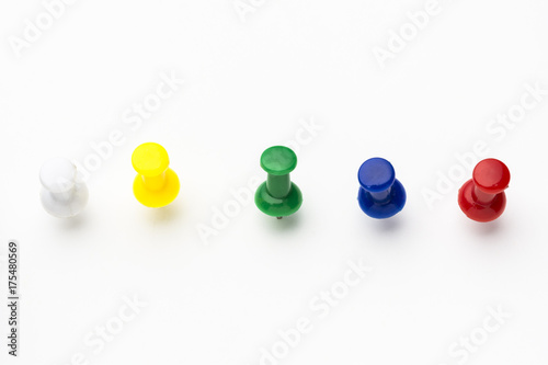 Five colored push pins on white background