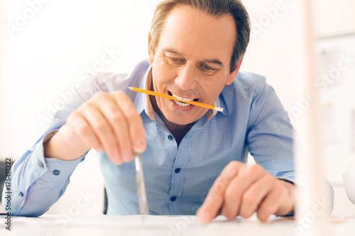Experienced nice architect holding a pencil