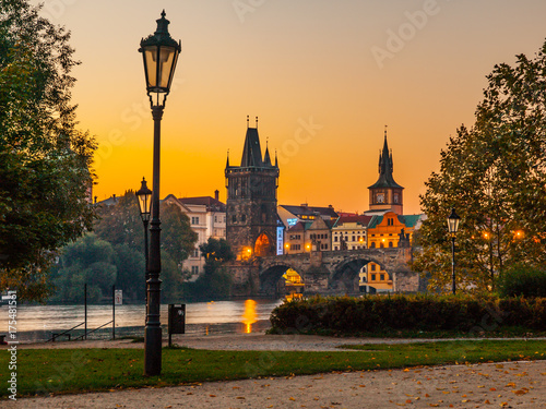 Embankment with old lamp in Old Town of Prague with Charles Bridge and Vltava river. Early morning shot. Prague, Czech Republic.