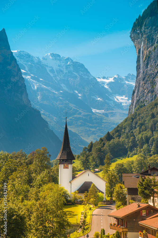 The picturesque landscape with waterfall and canyon church in Lauterbrunnen in the Swiss Alps, Switzerland, Europe