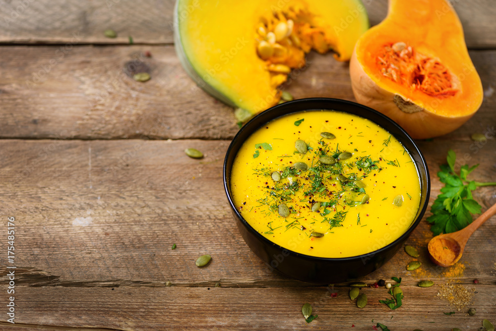 Vegetable and lentils creamy soup, cut pumpkin, seeds, parsley on rustic wooden background. Top view, copy space Vegetable and lentils creamy soup, cut pumpkin, seeds, parsley on rustic wooden background. Top view, copy space