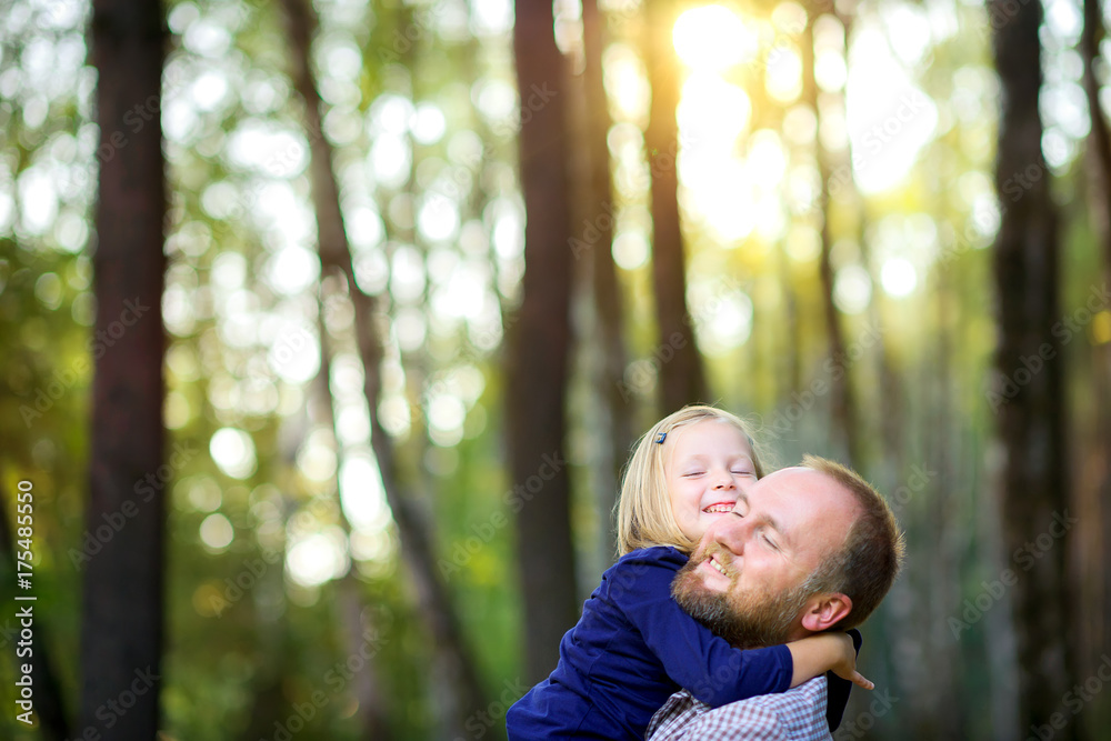 dad walks in the park with his beloved daughter at sunset, holds and hugs dad walks in the park with his beloved daughter at sunset, holds and hugs