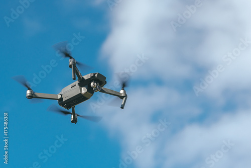 Flying drone on blue sky background