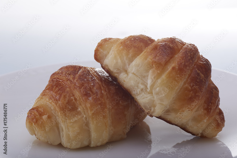 Tasty croissants with plate on white  backgound