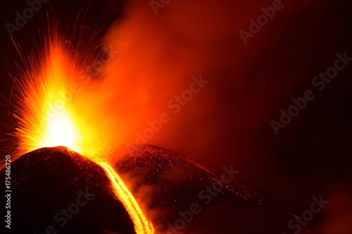 Vulcano Etna in eruzione con esplosione di lava e colata lavica photo