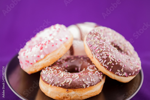 Donuts in plate over pink background. Delicious junk food