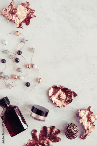 Fall beauty products with rose gold leaves flatlay on white marble background. Copy space. Blogging concept