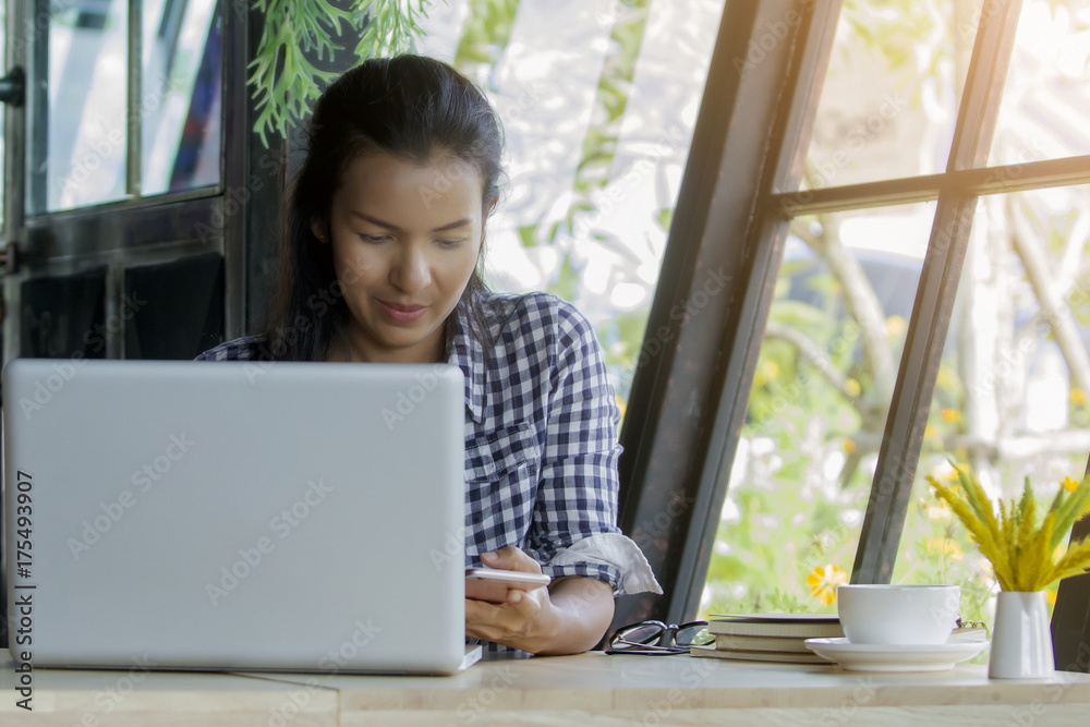 asia woman smailing using smart phone in coffee shop,technology communication lifestyle concept asia woman smailing using smart phone in coffee shop,technology communication lifestyle concept