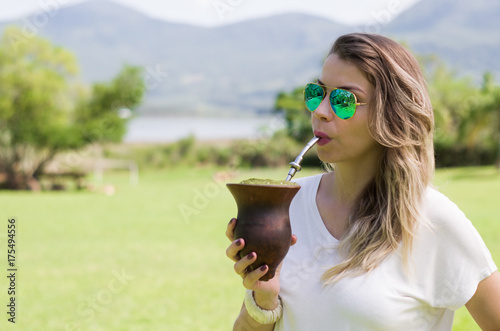 Jovem mulher bebendo, tomando chimarrão, 20 de setembro, rio grande do sul, tradição gaúcha. photo