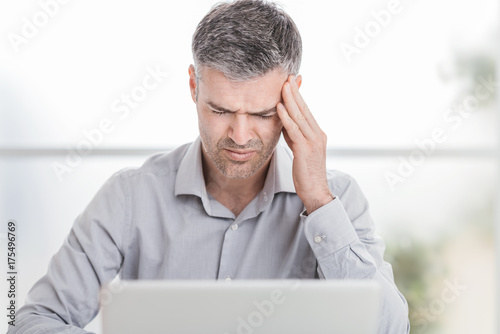 Stressed businessman with headache photo