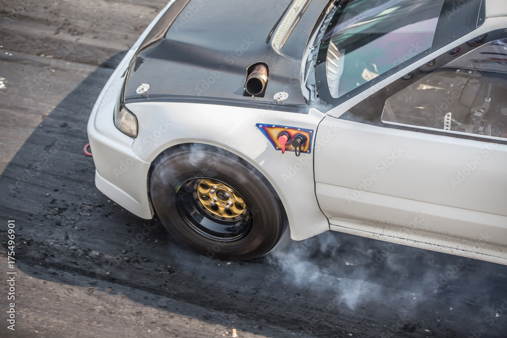 Front wheel drive sport car burning tire for warm up before competition start to increase type temperature for good traction.