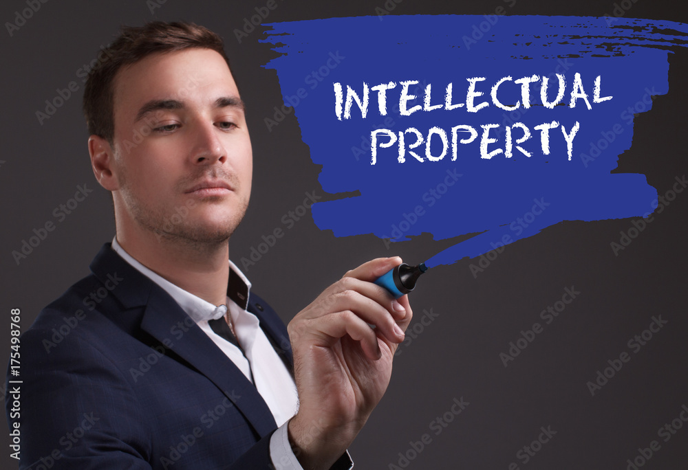 The concept of business, technology, the Internet and the network. Young businessman showing inscription: Intellectual property The concept of business, technology, the Internet and the network. Young businessman showing inscription: Intellectual property
