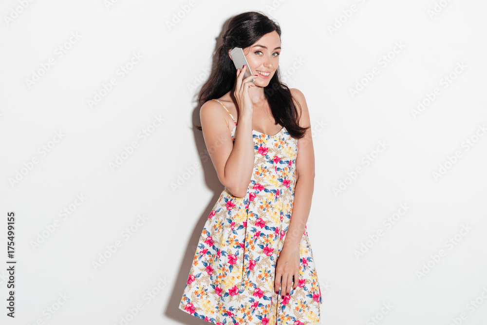 Smiling brunete woman talking by smartphone and looking at camera Smiling brunete woman talking by smartphone and looking at camera