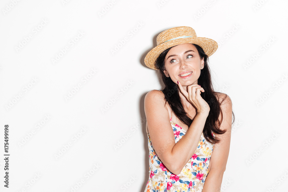 Smiling brunette woman in dress and hat looking away Smiling brunette woman in dress and hat looking away