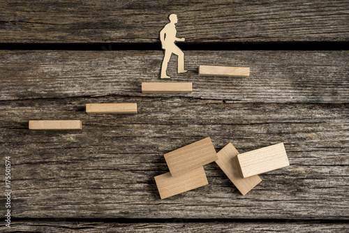 Silhouette cutouts of a man walking up wooden steps photo