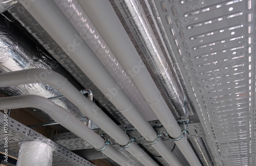 Heating and water cooling pipes attached to ceiling in office buidling