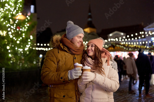 happy young couple with coffee at christmas market