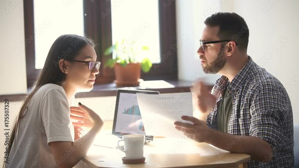Man and woman arguing disagreeing about bad business contract, colleagues having conflict dispute about document sitting at office desk, partners shouting breaking agreement with unacceptable terms Man and woman arguing disagreeing about bad business contract, colleagues having conflict dispute about document sitting at office desk, partners shouting breaking agreement with unacceptable terms