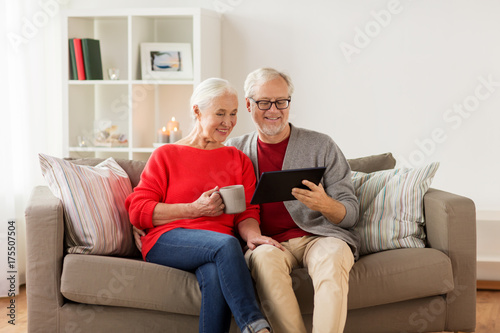 happy senior couple with tablet pc at christmas