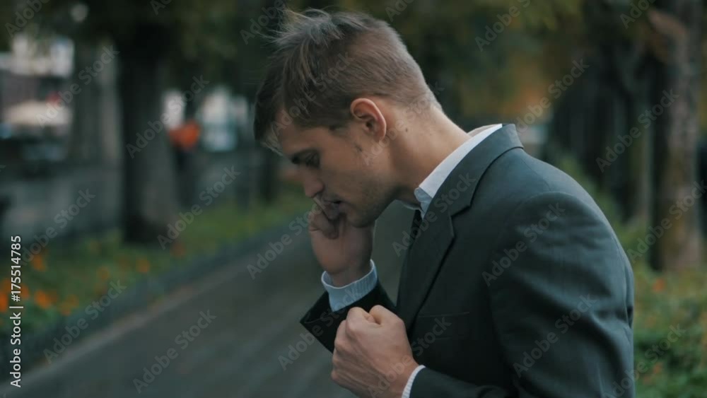 Young handsome businessman talking on mobile phone in the city. Guy heard good news and he is happy. Success concept. The joy of speaking on the phone. Slow motion. Young handsome businessman talking on mobile phone in the city. Guy heard good news and he is happy. Success concept. The joy of speaking on the phone. Slow motion.