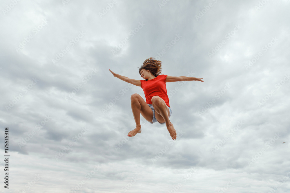 happiness, freedom, motion and people concept - smiling young woman jumping in air over sky background happiness, freedom, motion and people concept - smiling young woman jumping in air over sky background