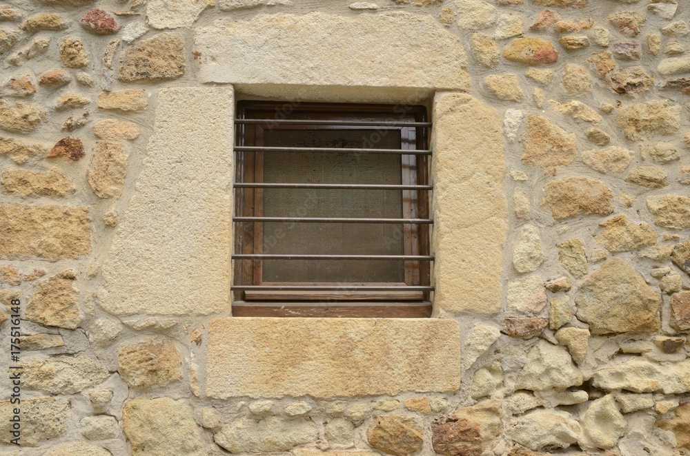 Window on stone wall  in Pals, Girona, Spain