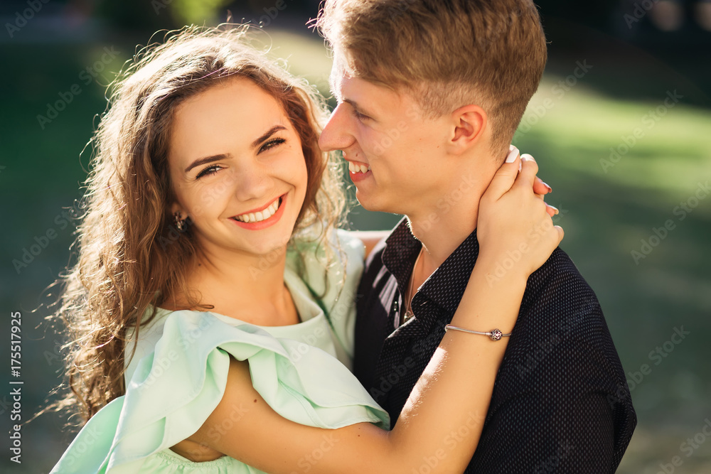 Loving couple - husband and wife - hugging and laughing in the park on a sunny summer day Loving couple - husband and wife - hugging and laughing in the park on a sunny summer day