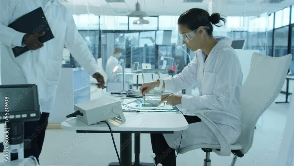  Electronics engineers working in lab building & testing circuitry & robotics